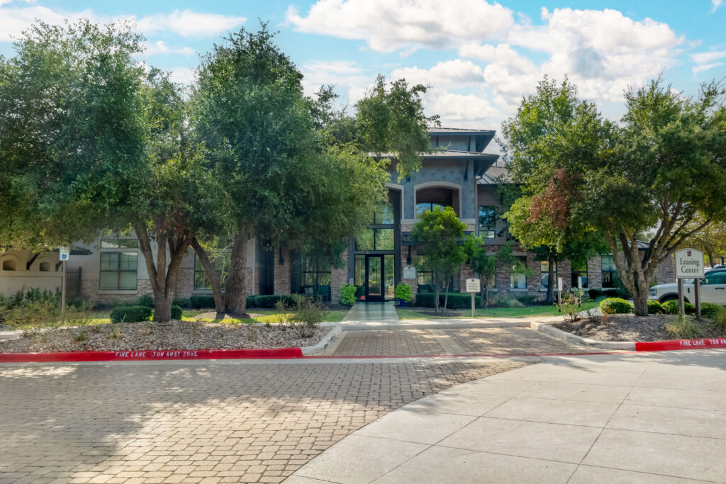 Leasing office exterior, lots of big trees and lush landscaping