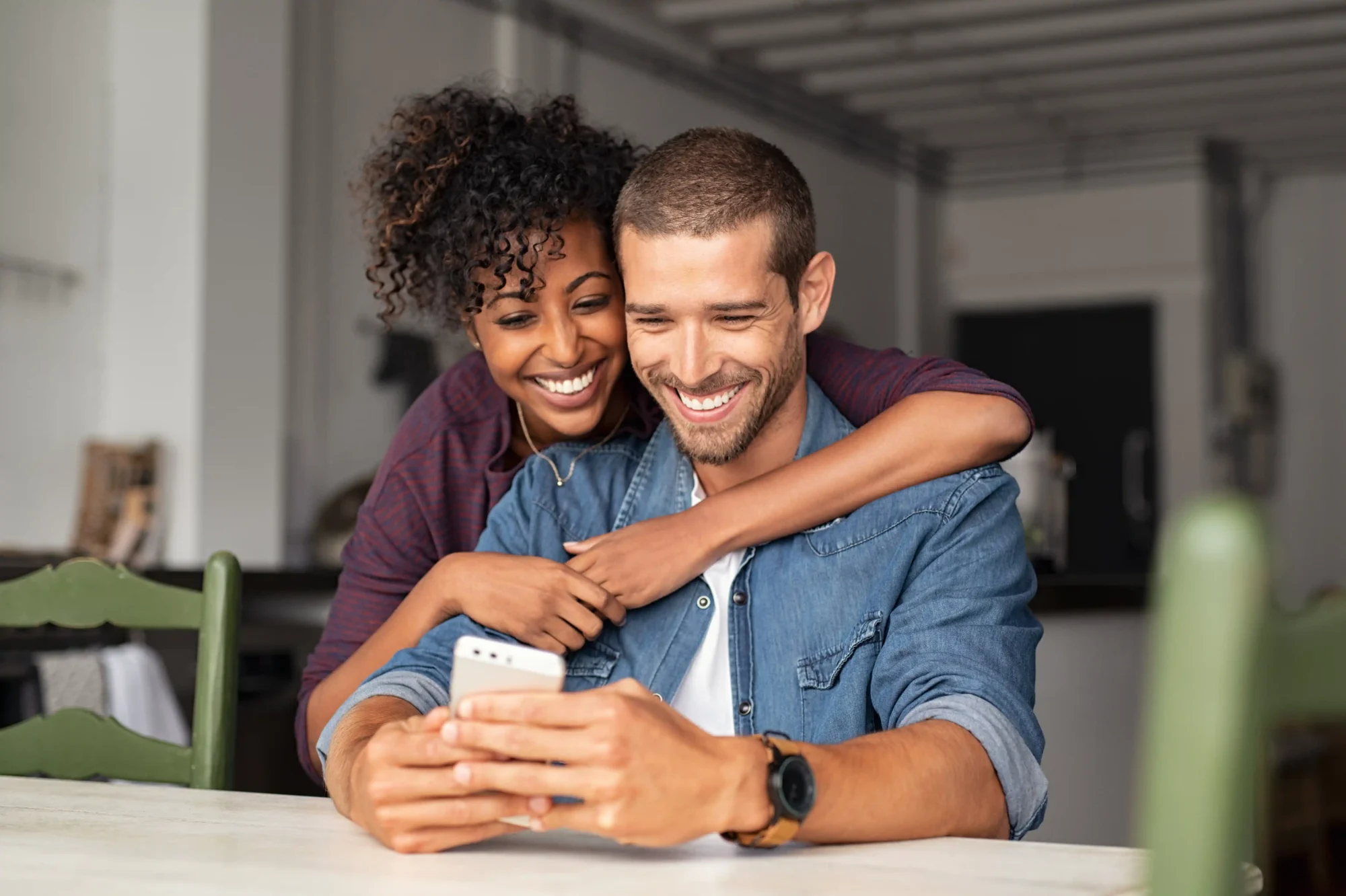 Young couple smiling and looking at a phone